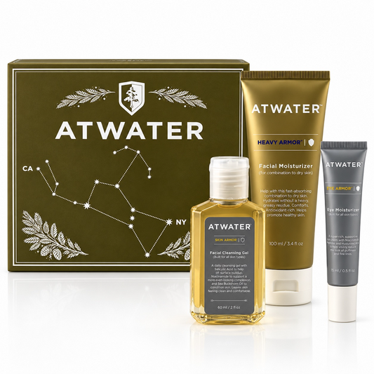 ATWATER skincare gift set featuring a gold box with constellation graphics, a gold Facial Moisturizer tube, a yellow Facial Cleansing Gel bottle, and a gray Eye Moisturizer tube on a white reflective surface.